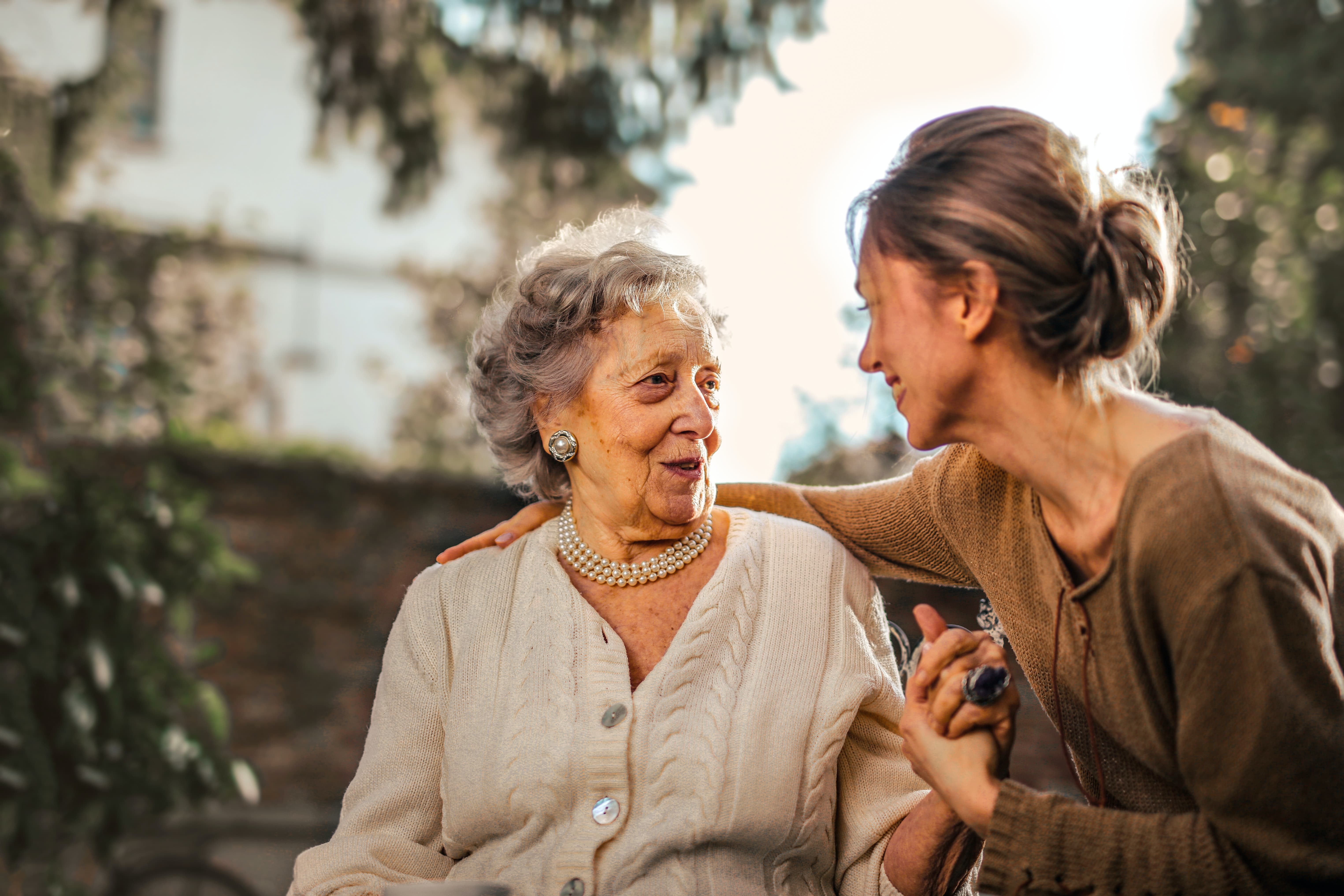 A women puts her arm around an older woman.